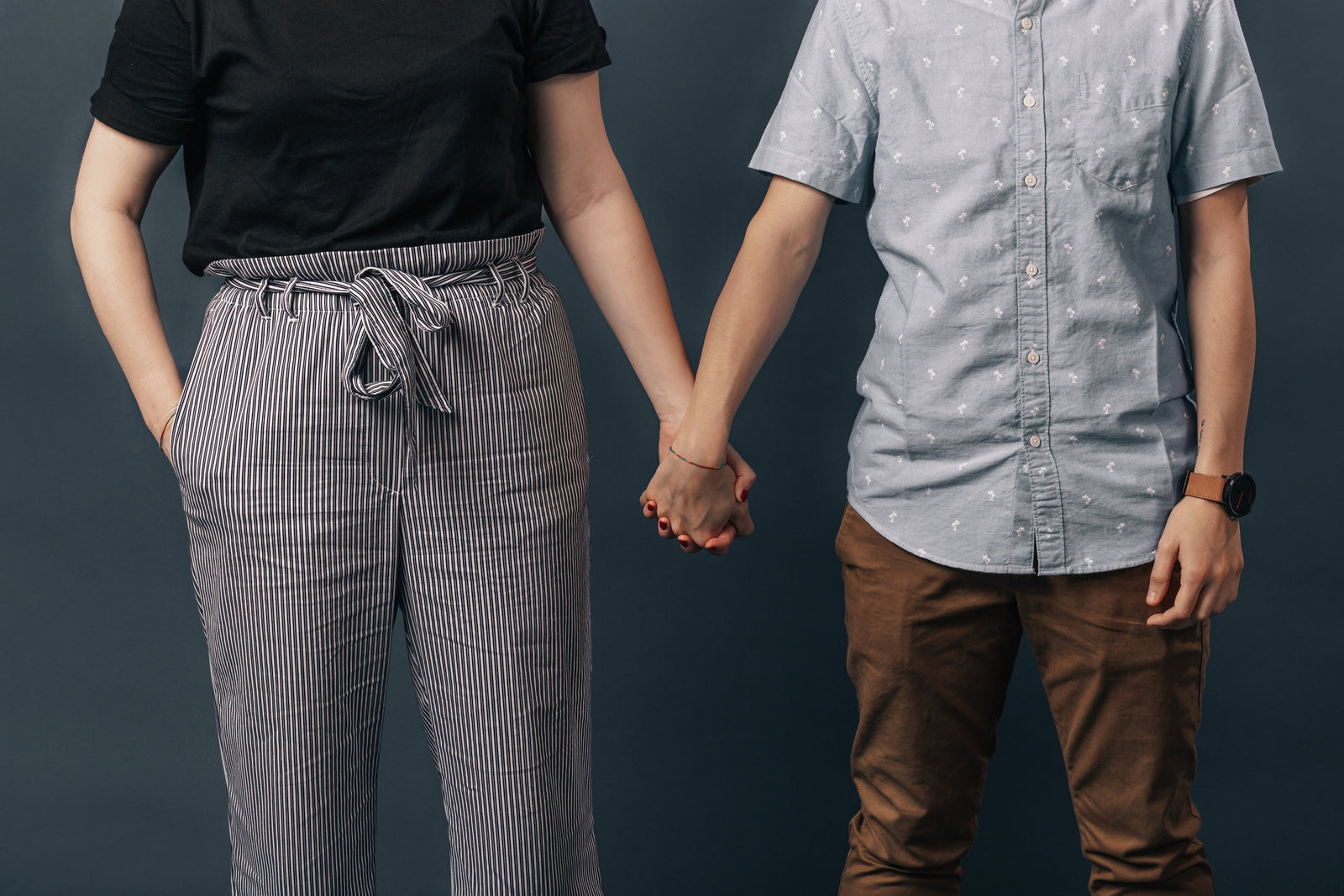 Two people holding hands side by side